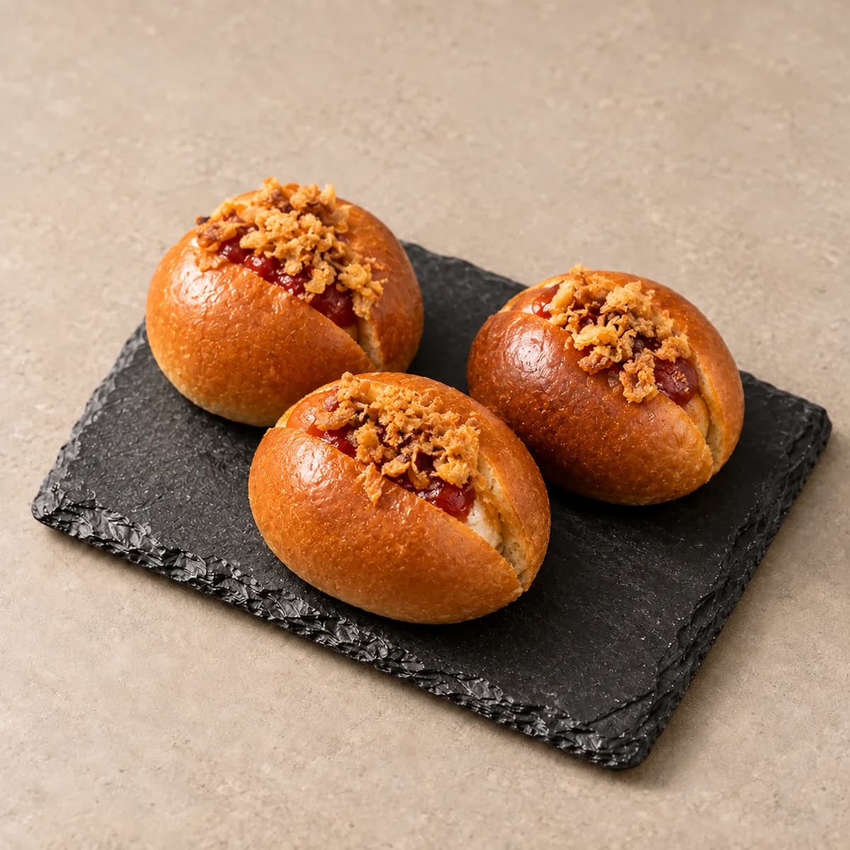 Mini hot-dogs dans leurs petits pains briochés ronds, garnis d’oignons croustillants