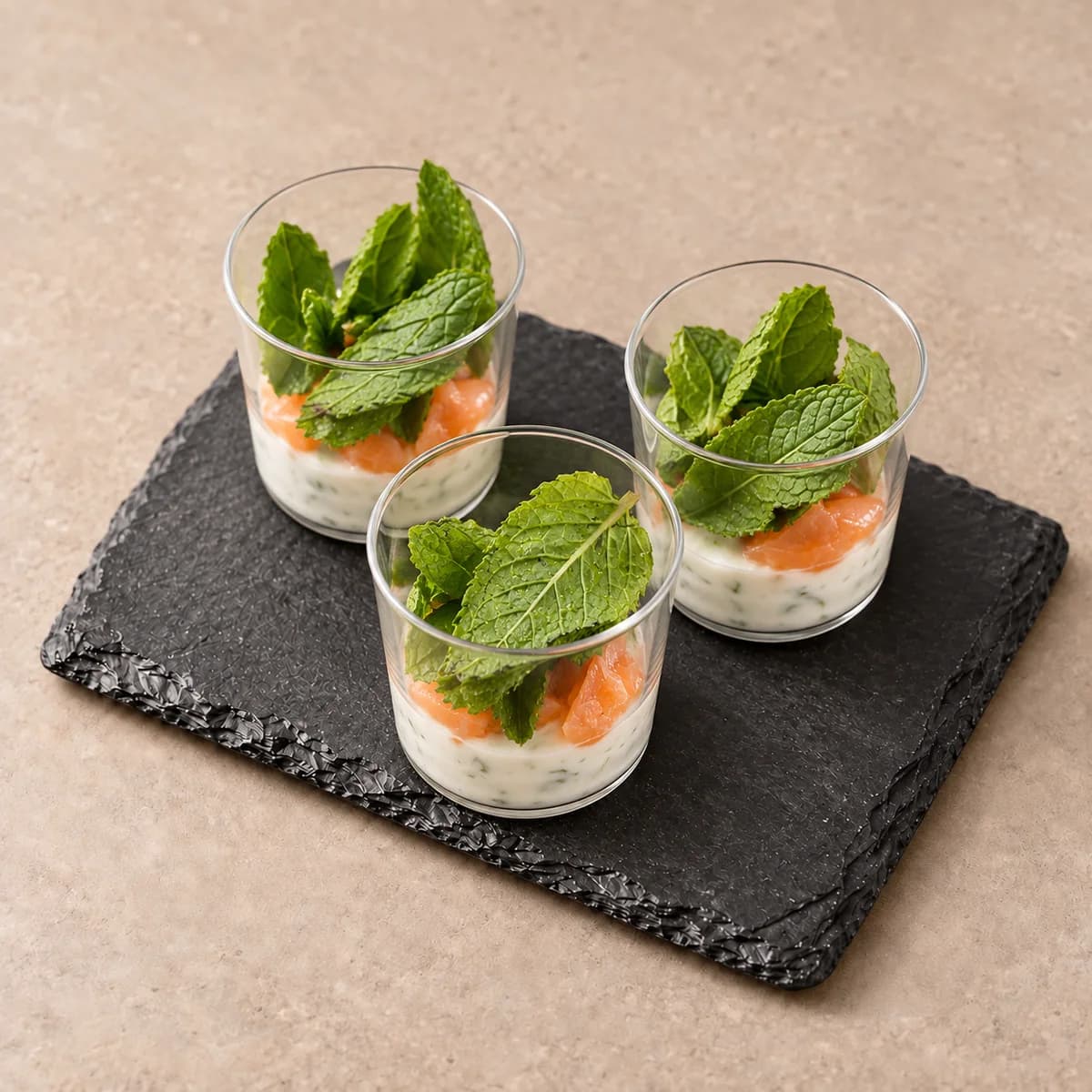 Verrines de saumon et tzatziki, garnies de menthe fraîche